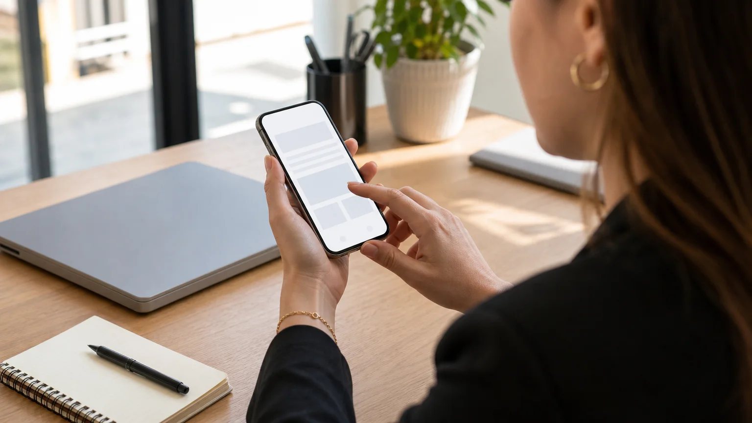 Entrepreneuse utilisant un site web sur smartphone dans un environnement professionnel